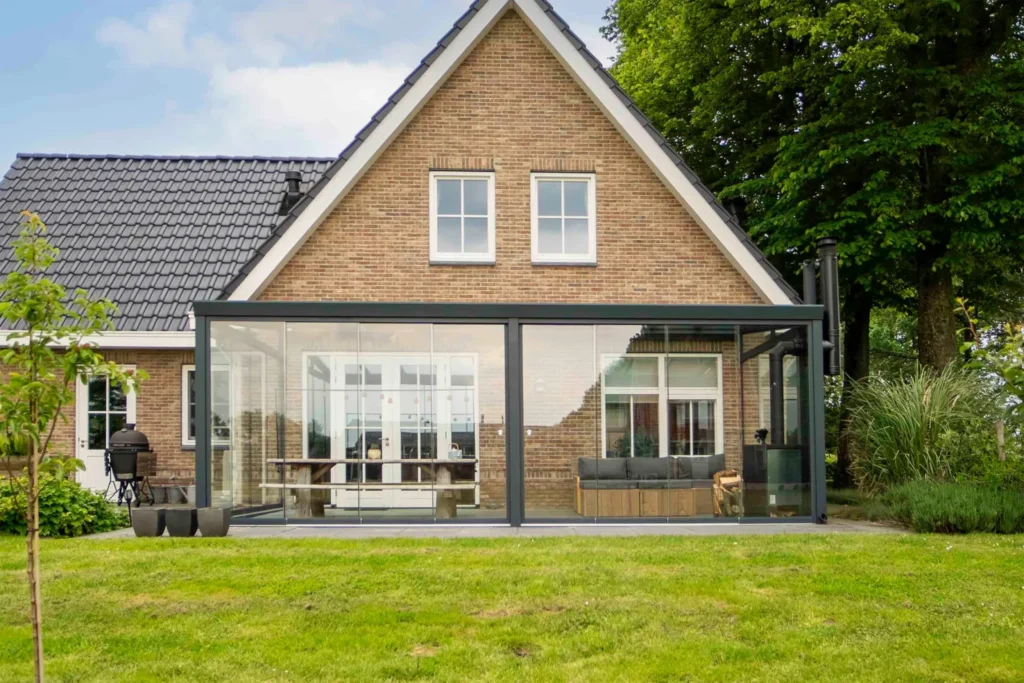 Aluxe TrendLine terrasoverkapping in antracietgrijs met panoramaschuifwanden, wigvormig zijraam en onderdaks zonwering